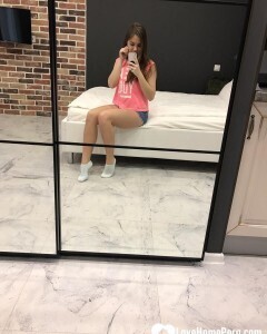 Horny teen plays with her phone while flashing